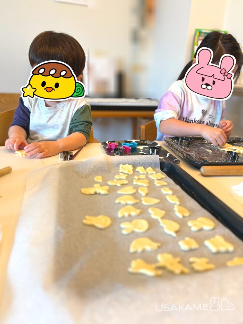 子ども2人がテーブルで型抜きクッキーを作っている様子