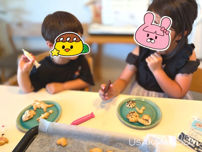 子ども2人がデコレーションしたクッキーを食べている様子